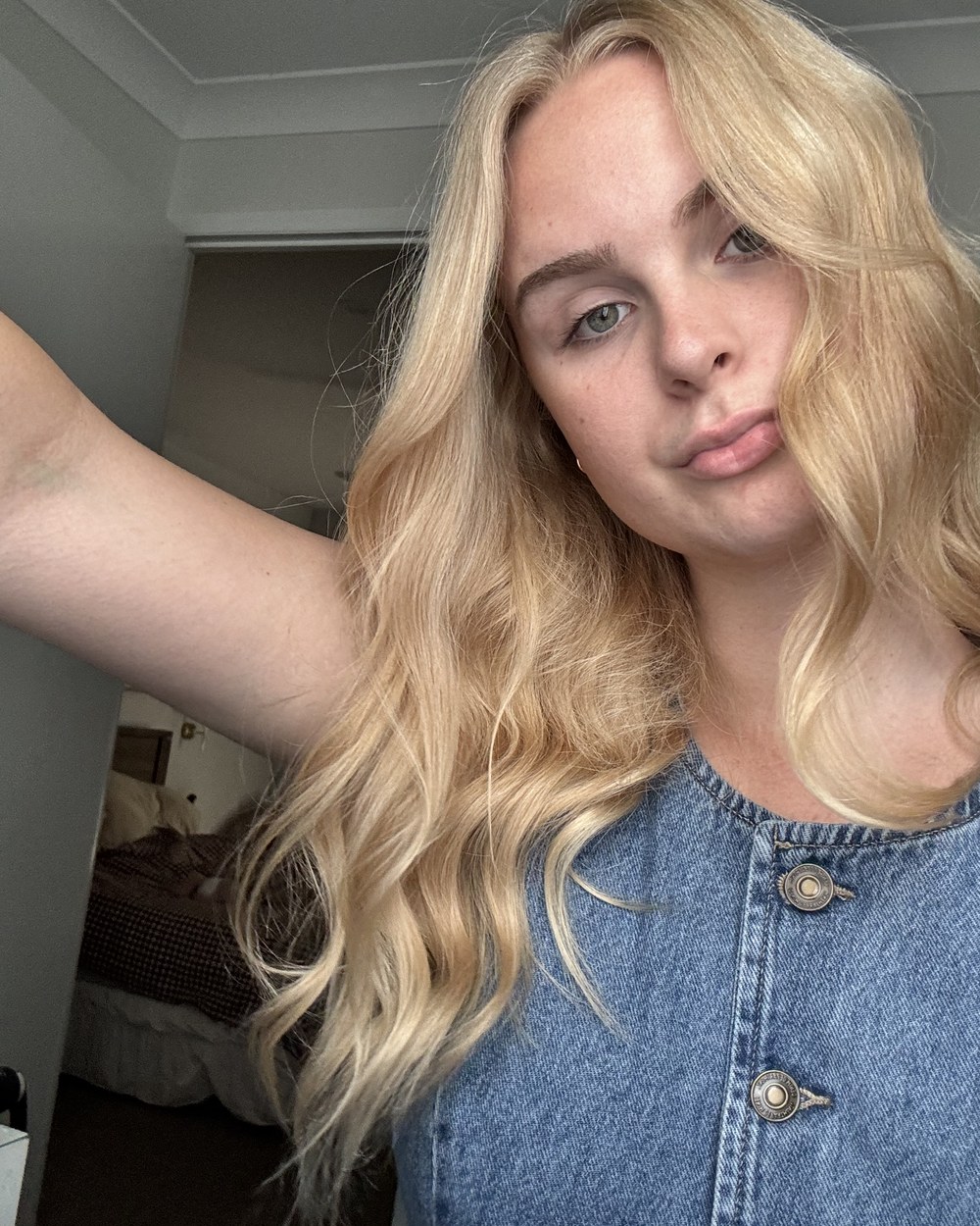 Ashley at home, long blonde hair, in a denim dress
