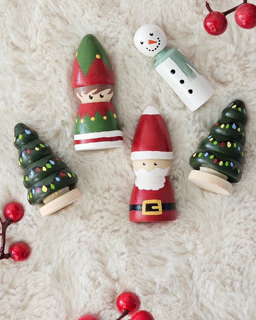 Hand painted Christmas pieces: a Santa, an elf, a snowman and two trees strung with lights